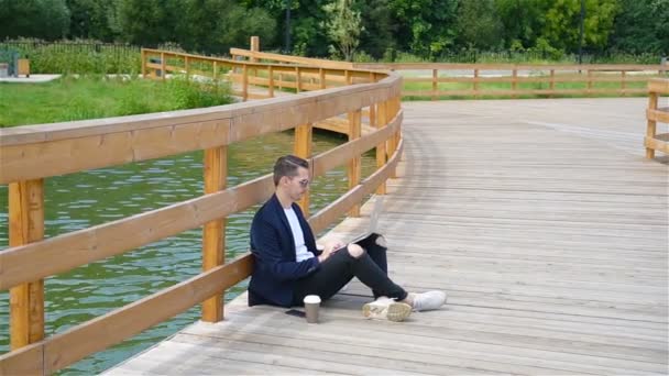 Heureux jeune homme urbain travaillant et buvant du café dans la ville européenne en plein air — Video