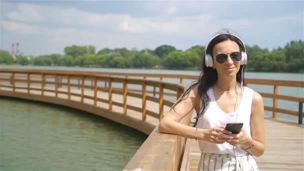 Щаслива молода міська жінка насолоджується музикою на відкритому повітрі — стокове відео