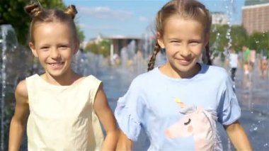 Küçük sevimli kız sokak Çeşmesi sıcak güneşli gün eğlenmek