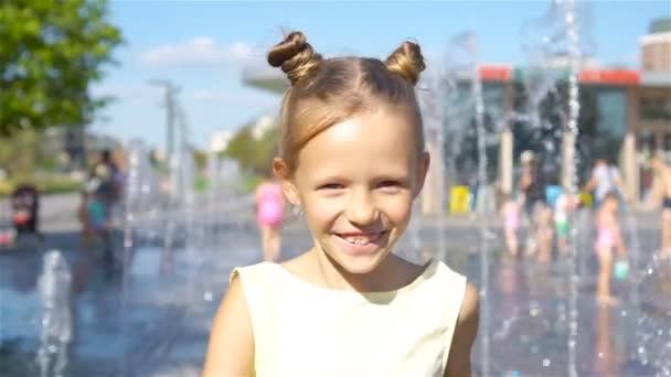 小可爱的女孩在街头喷泉的乐趣在炎热的阳光夏日 — 图库视频影像