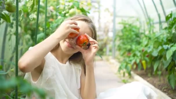 Retrato de niño con el tomate grande en las manos en invernadero — Vídeo de stock