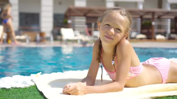 Hermosa niña divirtiéndose cerca de una piscina al aire libre — Vídeos de Stock