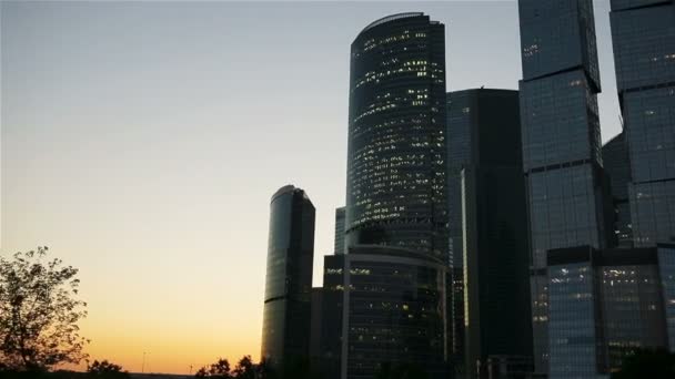 Gökdelen günbatımı güneş gökyüzünde ile üzerinde cam cepheler. Modern şehir iş İlçesi'nde modern binalar. — Stok video