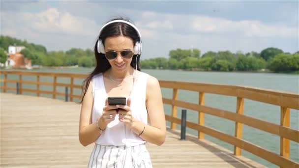 Joyeux jeune femme urbaine profiter de la musique en plein air — Video