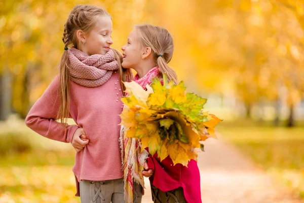 Little adorable girls at warm day in autumn park outdoors — Stock Photo, Image