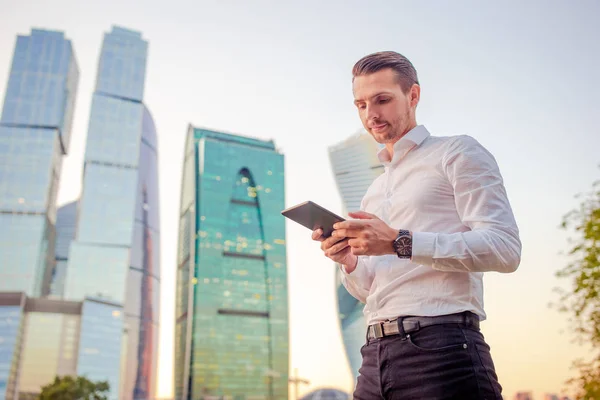 Joven hombre caucásico sosteniendo smartphone para el trabajo de negocios . — Foto de Stock