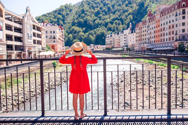 Meisje bij hat aan de kade van een rivier berg in een Europese stad. — Stockfoto
