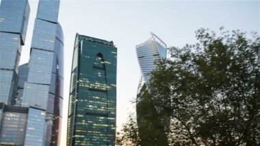 Gökdelen günbatımı güneş gökyüzünde ile üzerinde cam cepheler. Modern şehir iş İlçesi'nde modern binalar.