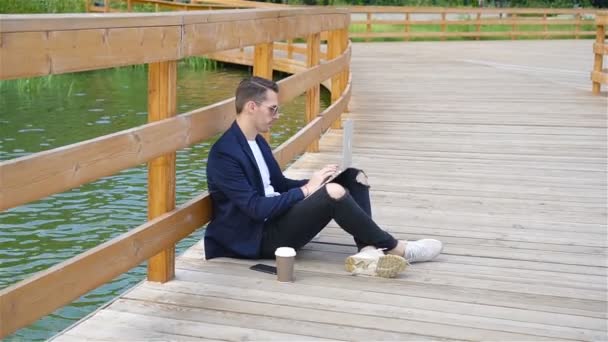 Jovem homem urbano feliz trabalhando e bebendo café na cidade europeia ao ar livre — Vídeo de Stock