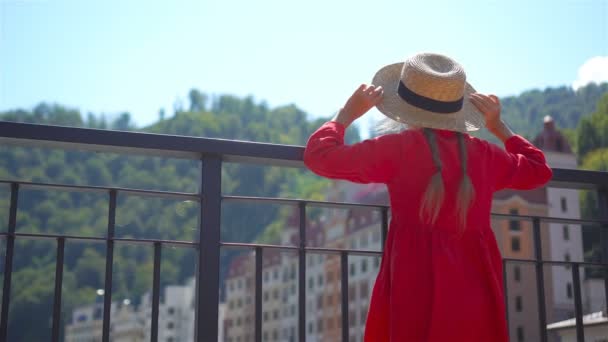 Menina em chapéu no dique de um rio de montanha em uma cidade europeia . — Vídeo de Stock