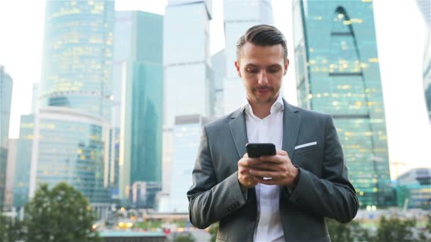 Jeune homme caucasien tenant smartphone pour le travail d'affaires . — Video