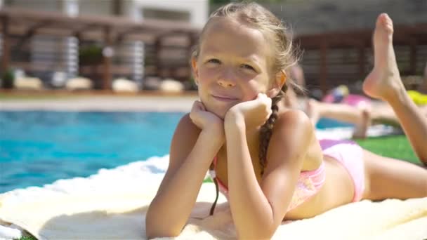 Bella bambina si diverte vicino a una piscina all'aperto — Video Stock
