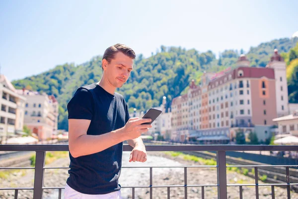 Hombre en el terraplén de un río de montaña en una ciudad europea . —  Fotos de Stock