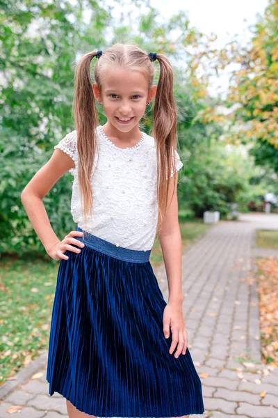 Adorable niña de la escuela con notas y lápices al aire libre . —  Fotos de Stock