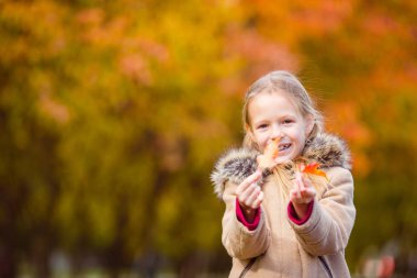 Dışarıda güzel bir sonbahar gününde sevimli küçük bir kız.