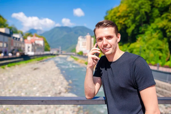 Hombre en el terraplén de un río de montaña en una ciudad europea . —  Fotos de Stock