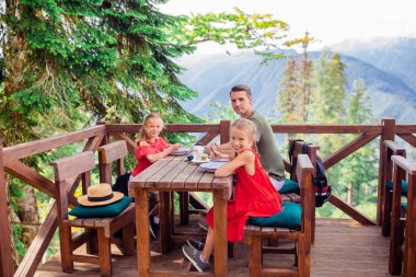 Sis arka planda dağlarda çocuklarla güzel mutlu baba