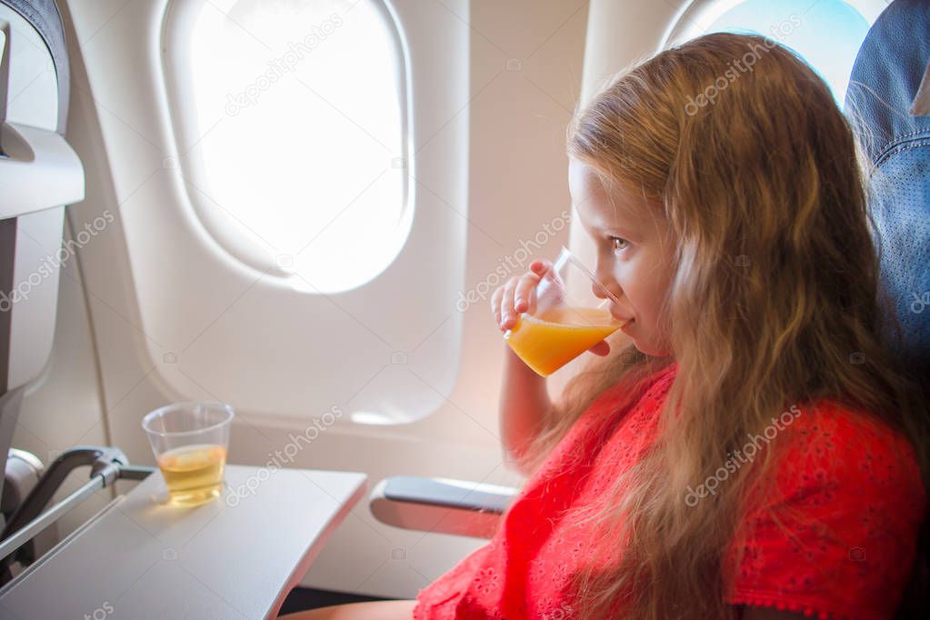 Adorable little girl traveling by an airplane.