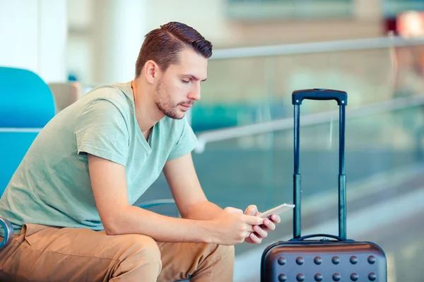 Young man in an airport lounge waiting for flight aircraft. — Stock Photo, Image