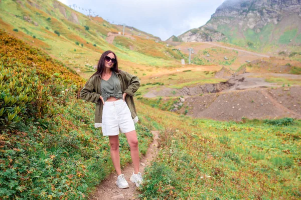 Belle jeune femme heureuse dans les montagnes dans le fond de brouillard — Photo