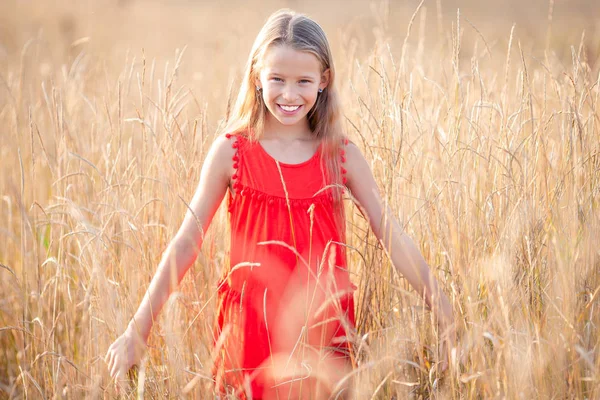 Piękne blond dziewczynka, ma szczęśliwy wesoły zabawa uśmiechnięta twarz, czerwona sukienka — Zdjęcie stockowe