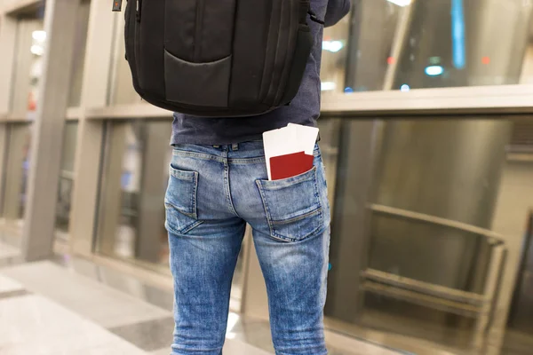 Passaportes de close-up e cartão de embarque no bolso de jeans no aeroporto — Fotografia de Stock