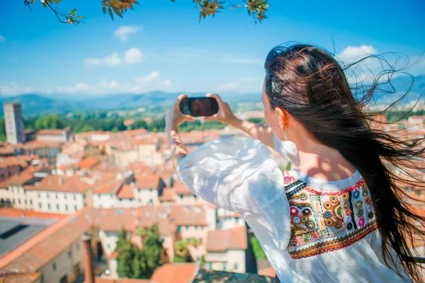 Mladá Kavkazský žena tím mobilních telefonů, Foto staré město z místa pozorování — Stock fotografie