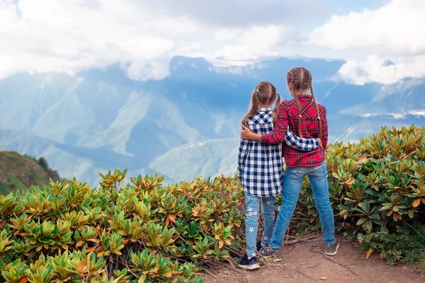 Beautiful happy little girls in mountains in the background of fog — Stock Photo, Image