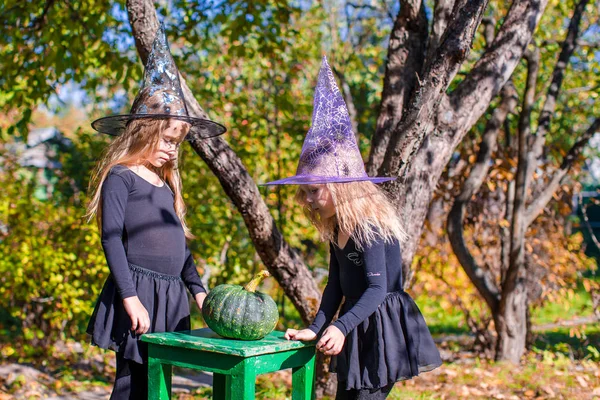 Adorable little witches have fun outdoors on Halloween. Trick or treat. — Stock Photo, Image