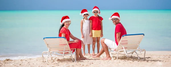 Glückliche Familie mit zwei Kindern in Santa Hat im Sommerurlaub — Stockfoto