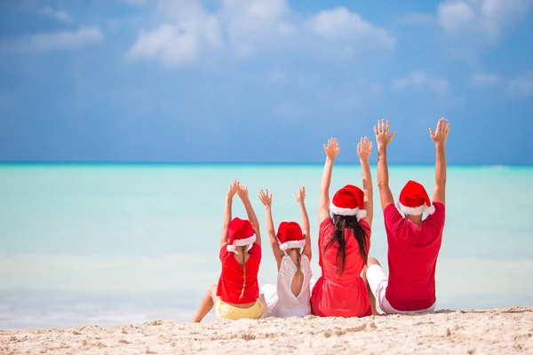 Glückliche Familie mit zwei Kindern in Santa Hat im Sommerurlaub — Stockfoto