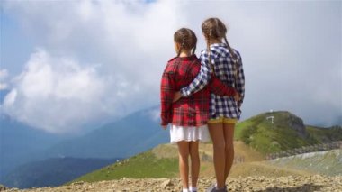 Sisin arkasındaki dağlarda güzel mutlu küçük kızlar.