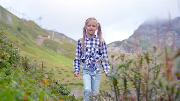 Hermosa niña feliz en las montañas en el fondo de la niebla — Vídeo de stock