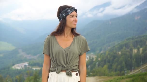 Mulher jovem feliz bonita em montanhas no fundo do nevoeiro — Vídeo de Stock