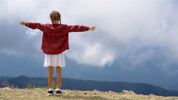 Hermosa niña feliz en las montañas en el fondo de la niebla — Vídeo de stock