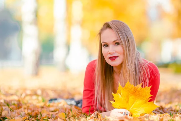 Höstkoncept - vacker kvinna dricker kaffe i höstparken under höstlövverk — Stockfoto