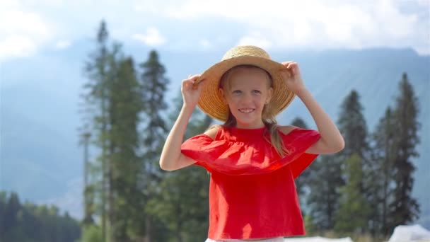 Schöne glückliche kleine Mädchen in den Bergen im Hintergrund des Nebels — Stockvideo