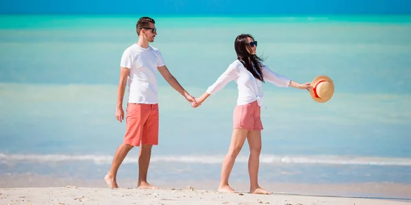 Νεαρό ζευγάρι στην παραλία με λευκή. Ευτυχισμένη οικογένεια σε διακοπές μήνα του μέλιτος — Φωτογραφία Αρχείου