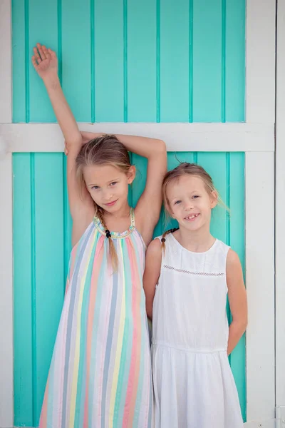 Adorable little girls on summer vacation background traditional colorful caribbean house — Stock Photo, Image