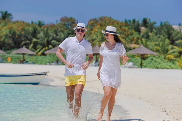 Pareja joven en la playa blanca. Familia feliz en vacaciones de luna de miel — Foto de Stock