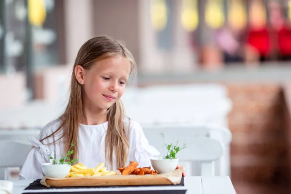 Adorable little girl having lunch at outdoor cafe — Stock Photo, Image