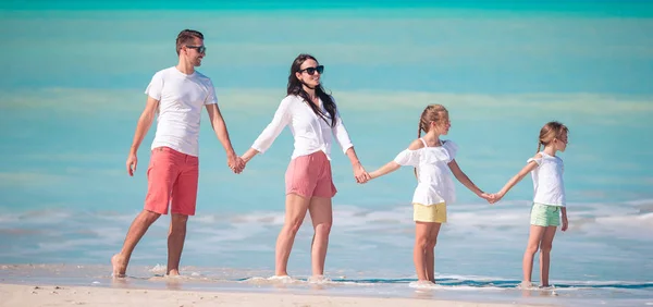 愉快的家庭与孩子在海滩漫步在日落 — 图库照片