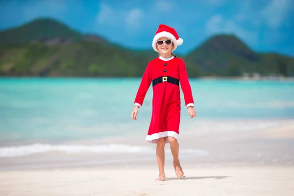 열 대 해변에 산타 모자에서 귀여운 어린 소녀 — 스톡 사진