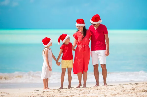 Glückliche Familie mit zwei Kindern in Santa Hat im Sommerurlaub — Stockfoto