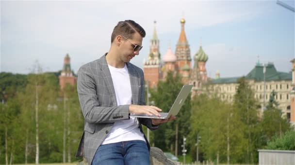 Homem está trabalhando por laptop enquanto relaxa no parque — Vídeo de Stock