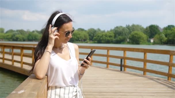Glada unga urbana kvinnan njuta av musik utomhus — Stockvideo