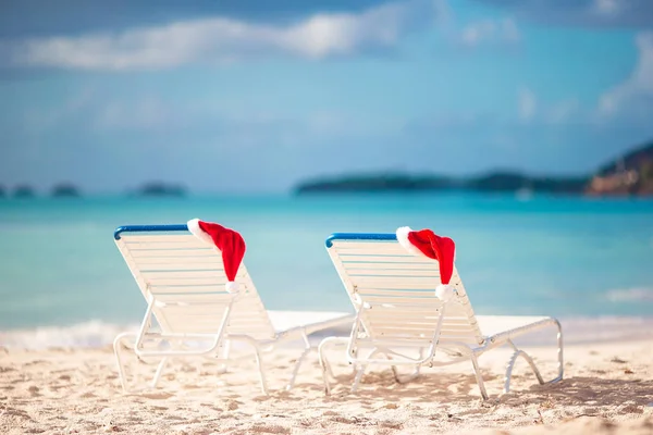 Cappello Babbo Natale primo piano su sedia sulla spiaggia tropicale bianca — Foto Stock