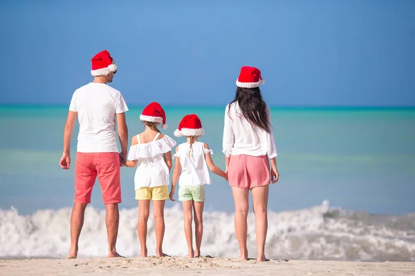 Glückliche Familie mit zwei Kindern in Santa Hat im Sommerurlaub — Stockfoto