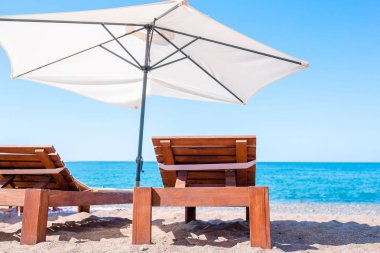 Maldivler 'de güzel bir tropikal sahilde beyaz şezlonglar.