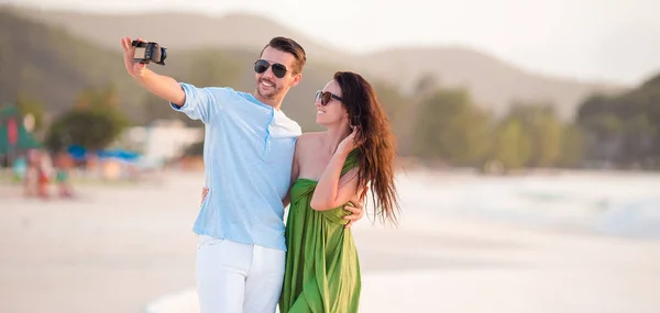 Šťastný pár fotografování selfie na bílé pláži. — Stock fotografie